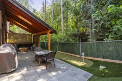 Fenced back yard with putting green and cover